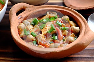 Tofu, mushroom cook with soy sauce in terra cotta pot