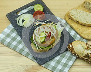 tofu patties on ciabatta bread with tomatoes, onion cucumber and lettuce