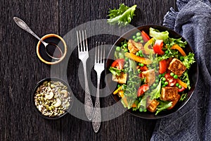 Tofu salad with greens and vegetables in bowl