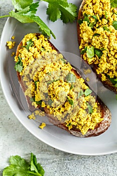 Tofu scramble sandwich on a gray plate, top view. Vegan food concept