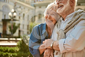 Always together. Happy senior couple bonding to each other and smiling while spending time together outdoors