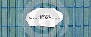 TOGETHER WE MAKE THE DIFFERENCE text on the piece of paper on the green wood background photo