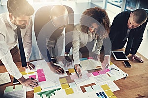 Together, they miss nothing. a group of businesspeople going over paperwork during a meeting in their office.