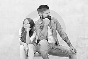 Together is our favorite place to be. Serious daughter and dad sit on stool. Father child relations. Bearded man and