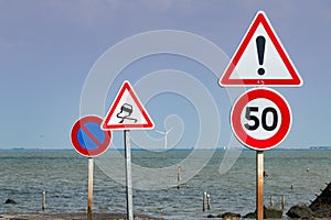 Together of road signs next to sea