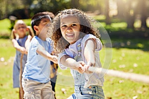 Together a team achieves more. a group of kids playing a game of tug of war at summer camp.