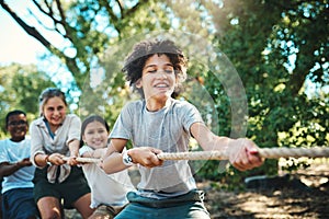 Together a team achieves more. a group of teenagers playing a game of tug of war at summer camp.