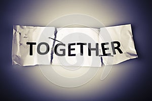 Together word on torn paper stapled back