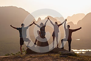 Togetherness concept with silhouettes against sunrise and mountains