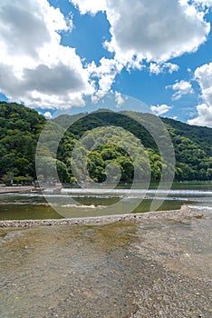 Togetsu-kyo bridge over katsuragawa river with colourful forest mountain background in Arashiyama district.