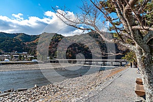 Togetsu-kyo bridge over katsuragawa river with colourful forest mountain background in Arashiyama district.