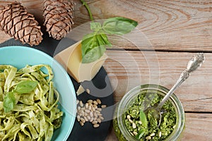 Togliatti with Pesto sauce in a blue plate next to the ingredients on a wooden table, copy space for your text