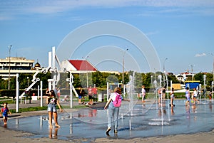 Children play with jets of a fountain on a hot sunny afternoon in the park of the 50th anniversary of JSC AvtoVAZ.