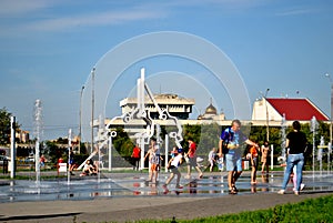 Children play with jets of a fountain on a hot sunny afternoon in the park of the 50th anniversary of JSC AvtoVAZ.