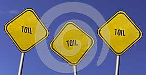 Toil - three yellow signs with blue sky background