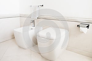 Toilet and bidet in a modern bathroom - lid closed.