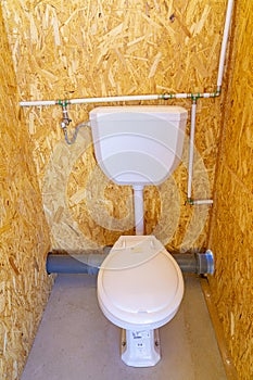 toilet and cistern inside a public bathroom built in chipboard photo