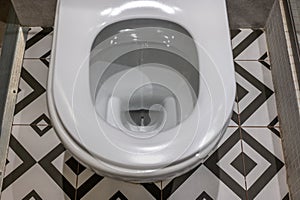 Toilet close up, water flushing in toilet, A photo of a white ceramic toilet bowl. White toilet bowl in a bathroom