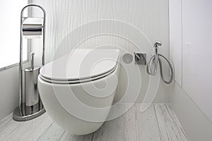 Toilet and detail of a corner shower bidet with wall mount shower attachment