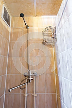 toilet and detail of a corner shower cabin with wall mount shower attachment