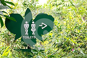 Toilet direction board in the garden,Toilet sign on butterfly shape board style background