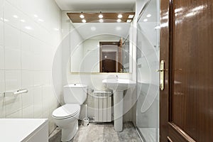 Toilet with gray concrete floor, glass partitioned shower stall,