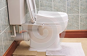 Toilet with height extension for disabled senior person indoors in house