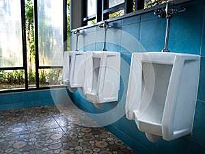 Toilet men`s room.Close up row of outdoor urinals men public toi