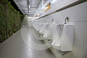 toilet men`s room.Close up row of outdoor urinals men public toilet,Closeup white urinals in men`s bathroom