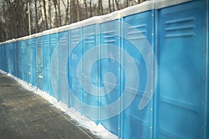 Toilet outside. Toilets stand in row. Blue booths