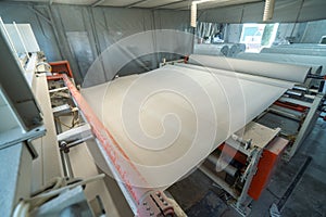 Toilet paper production. Machine with a large roll of recycled paper