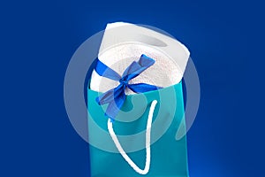 Toilet paper roll in gift box on blue background. concept.