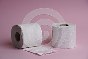 Toilet paper roll on pink background. Hygienic soft paper