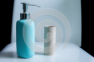 Toilet paper roll placed on a commod along with hand soap. Hygeine concept