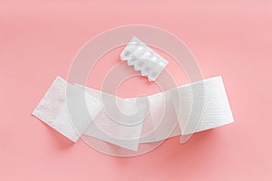 Toilet paper roll and rectal suppository for proctology diseases concept on pink background top view