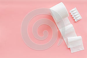Toilet paper roll and rectal suppository for proctology diseases concept on pink background top view mockup