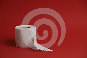 Toilet paper roll on red background. Soft hygienic paper