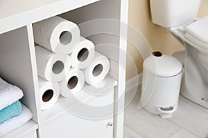 Toilet paper rolls on cabinet shelf