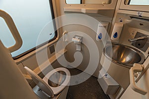 Toilet room with wash basin and mirror in expres train in cold winter day