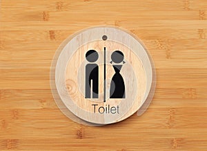 Toilet sign of male and female on natural wood for restroom with hardwood door panel background