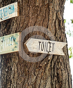 toilet sign. wooden sign hung over the entrance to toilet. Toilet pointer on the Old shabby wooden planks