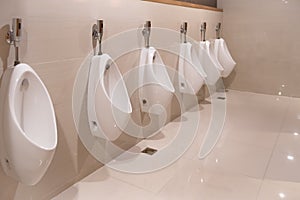 Toilet sink interior Men`s room urinals discharge ,Toilet bowl in a modern bathroom with bins and toilet