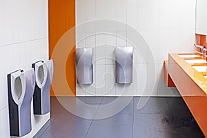 toilet with washbasins, hand dryers in a supermarket in orange colors