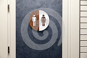 Toilet, wc icon, round wooden white and brown sign on restroom door in the hallway, restaurant, lobby. Concept sign of toilet room