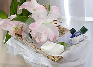 Toiletries in basket and pink lily