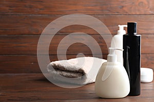 Toiletries and folded towel on wooden table