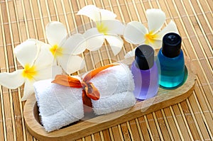 Toiletries with towel and plumeria flower