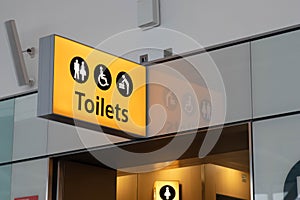 Toilets yellow light sign at airport with reflection