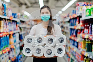 Toilette paper shortage.Woman with hygienic mask shopping for toilette paper supplies due to panic buying and product hoarding