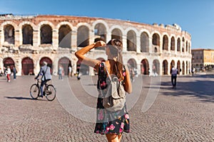 Toirust woman in Verona historical center on square near Arena Verona, Roman amphitheater. Traveler in famous travel destination